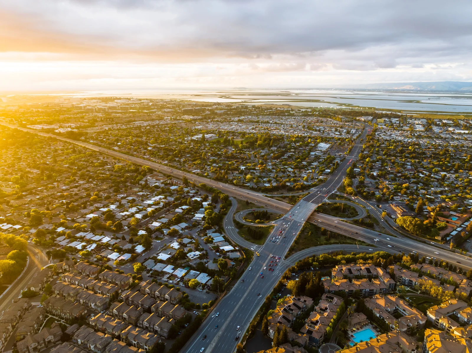 Urban neighborhoods, roads, and San Francisco Bay at sunset