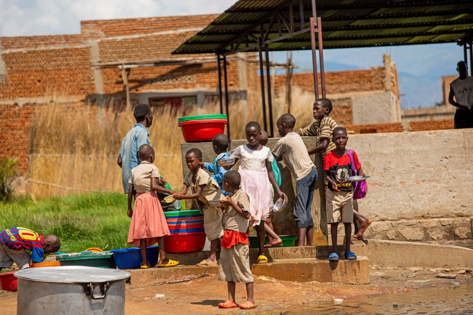 Children gathered around outdoor washing basins